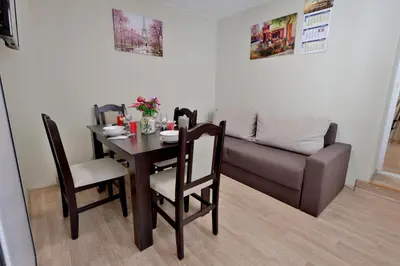 a dining room with a table and a couch at Varna Central Sea Apartment in Varna City