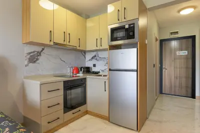 a kitchen with yellow cabinets and a white refrigerator at Azur Properties ap19 in Shkorpilovtsi