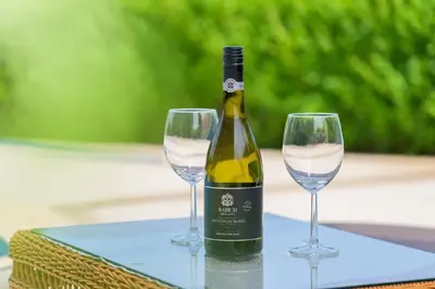 a bottle of wine and two wine glasses on a table at Azur Properties ap19 in Shkorpilovtsi