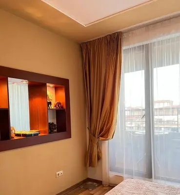 a bedroom with a window and a large window with a view at Green Life Sozopol in Sozopol