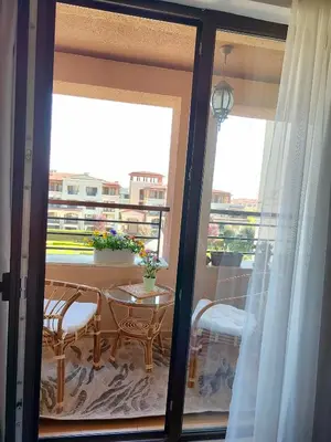 a room with a balcony with a table and a window at Green Life Sozopol in Sozopol