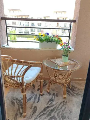 a table and a chair and a table with flowers on a balcony at Green Life Sozopol in Sozopol