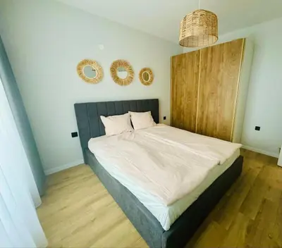 a bedroom with a large bed with two mirrors on the wall at South Beach Apartment Primorsko in Primorsko