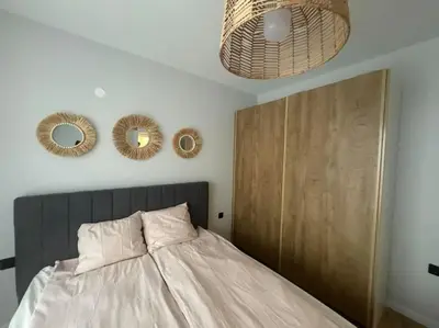 a bedroom with a bed and two mirrors on the wall at South Beach Apartment Primorsko in Primorsko