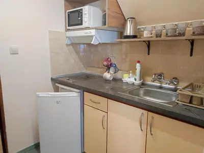 a small kitchen with a sink and a microwave at Апартамент с уникална панорама Несебър in Nesebar