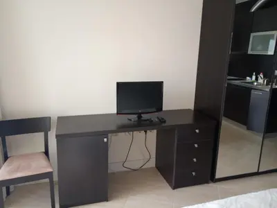a computer desk with a monitor and a chair at Piękny apartament nad morzem czarnym in Aheloy