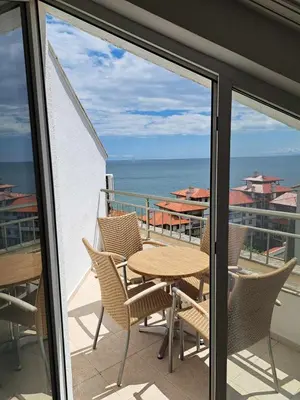 a balcony with a table and chairs and the ocean at Wspaniały apartament w kompleksie Galateya in Sveti Vlas