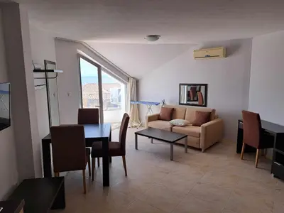 a living room with a table and a couch at Wspaniały apartament w kompleksie Galateya in Sveti Vlas