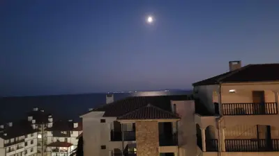 a view of the moon over buildings and houses at Wspaniały apartament w kompleksie Galateya in Sveti Vlas