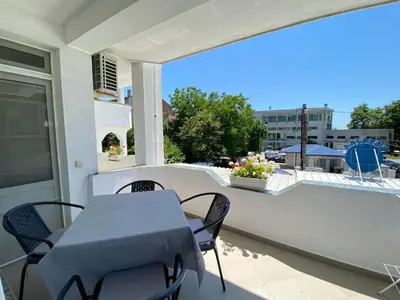 a patio with a table and chairs on a balcony at Guest House Ropotamo in Primorsko