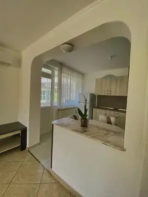 a kitchen with a counter in the middle of a room at Guest House Ropotamo in Primorsko