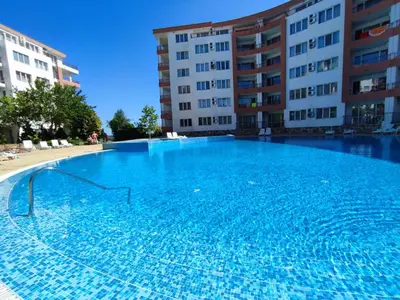 a large swimming pool in front of a building at Riviera Fort Beach Apartment in Ravda