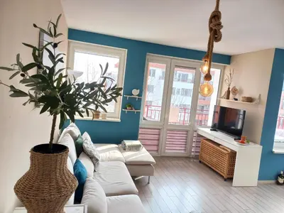 a living room with a white couch and a potted plant at Riviera Fort Beach Apartment in Ravda