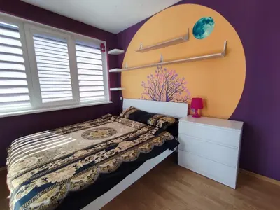 a purple bedroom with a bed and a window at Riviera Fort Beach Apartment in Ravda