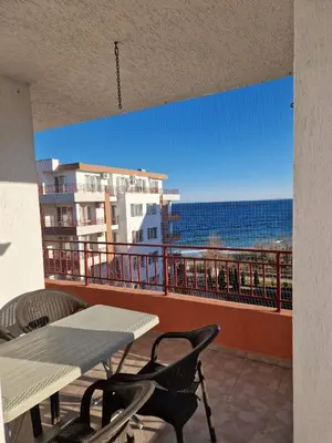 a balcony with a table and chairs and the ocean at Riviera Fort Beach Apartment in Ravda