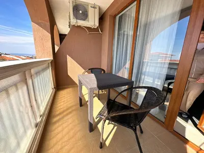 a balcony with two chairs and a table and a fan at 2 bedroom apartment Sveti Vlas with 2 balconies and sea views in Sveti Vlas