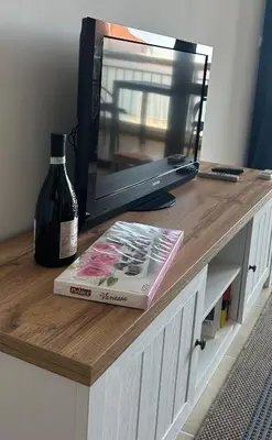 a book and a bottle of wine and a television at 2 bedroom apartment Sveti Vlas with 2 balconies and sea views in Sveti Vlas