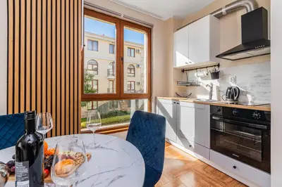 a kitchen with a table with a bottle of wine at Royal Bay Apartaments - Sveti Vlas in Sveti Vlas