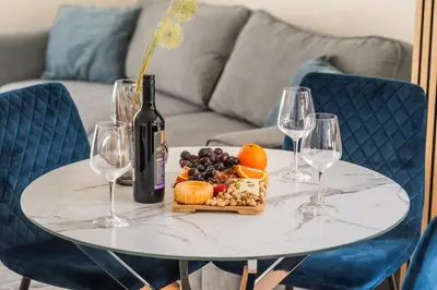 a white table with a bottle of wine and wine glasses at Royal Bay Apartaments - Sveti Vlas in Sveti Vlas