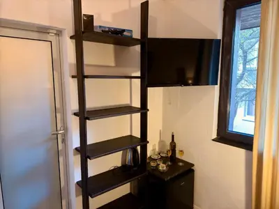a room with a shelf with a television and a table at Arthotel Oscar I Sozopol in Sozopol