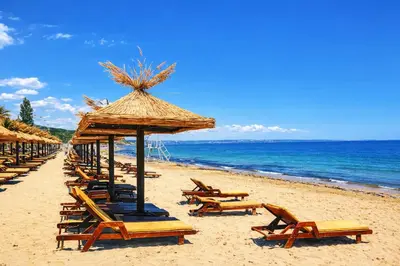 a group of chairs and umbrellas on a beach at Elegant Apartment Artur in Sveti Vlas
