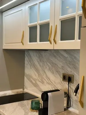 a kitchen with white cabinets and a counter at Santa Maria Luxury Suits in Ravda