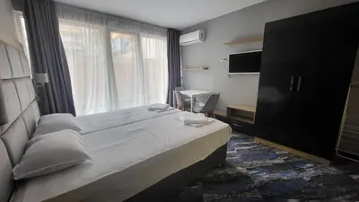 a bedroom with a large bed and a window at Marina Beach Apartments Pomorie in Pomorie
