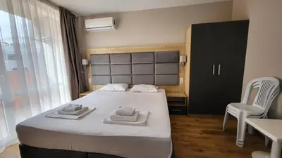 a bedroom with a bed with towels on it at Marina Beach Apartments Pomorie in Pomorie
