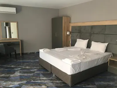 a bedroom with a large bed with white sheets at Marina Beach Apartments Pomorie in Pomorie