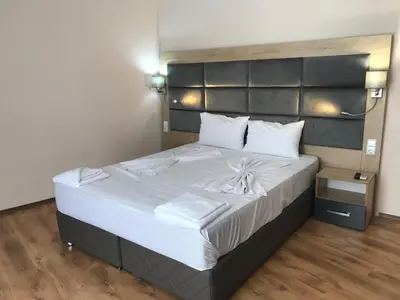 a bedroom with a large bed with white sheets at Marina Beach Apartments Pomorie in Pomorie