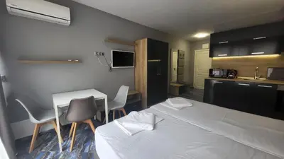a bedroom with a bed and a table and chairs at Marina Beach Apartments Pomorie in Pomorie