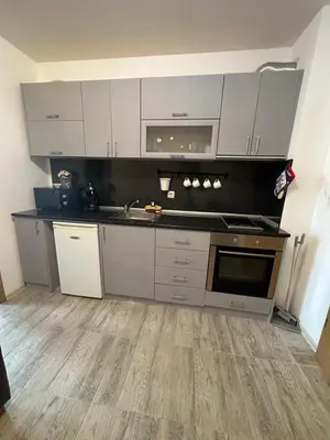 a kitchen with white cabinets and a sink at Оазис in Ravda