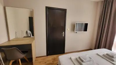 a bedroom with a bed and a desk and a mirror at Marina Bay Apartmant in Pomorie