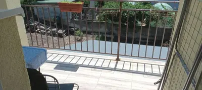 a balcony with a fence and a train on the tracks at Стаи за гости Пансионът на Роуз Вълшебната ми Кръстница in Chernomorets