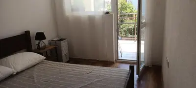 a bedroom with a bed and a large window at Стаи за гости Пансионът на Роуз Вълшебната ми Кръстница in Chernomorets