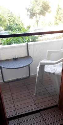 a porch with a chair and a table and a window at Stela in Burgas City