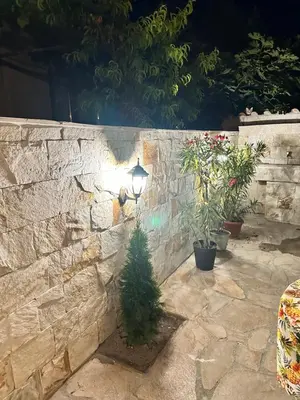 a light on a stone wall with a christmas tree at Double bed room in Nesebar