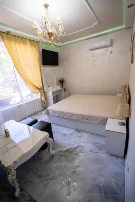 a bedroom with a bed and a table and a chandelier at AR Luxury Apartments Ravda in Ravda