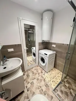 a bathroom with a washing machine and a sink at Panorama Dreams Apartment in Sveti Vlas