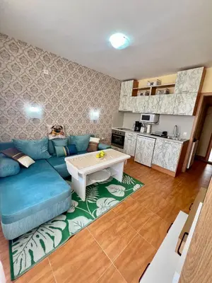 a living room with a blue couch and a table at Panorama Dreams Apartment in Sveti Vlas