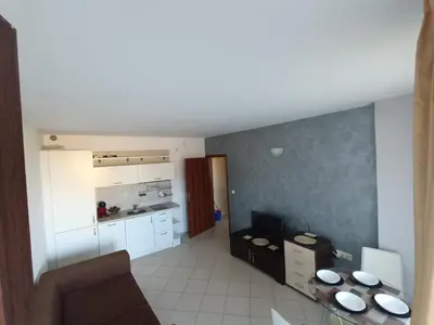 a kitchen with a table and a couch in a room at Oasis beach house , apartment Nevena in Lozenets