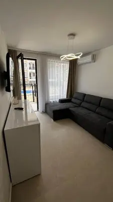 a living room with a black couch and a table at Polar Star 106 B in Saint Vlas in Sveti Vlas
