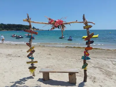 a wooden cross with a bench on the beach at Studio 41 in Ravda