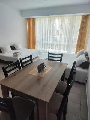 a dining room with a wooden table and chairs at Umi Apartments in Sunny Beach