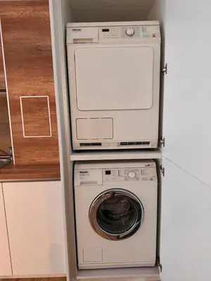 a washer and dryer in a corner of a kitchen at Goldy central beach apartment with private garden Burgas in Burgas City