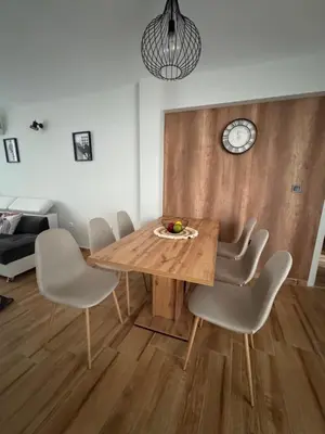 a dining room with a wooden table and chairs at Goldy central beach apartment with private garden Burgas in Burgas City