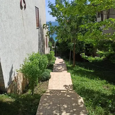 a walkway next to a building with a tree at Dolce Vita 1 Infinity Love in Sveti Vlas