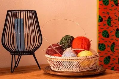 a basket of yarn on a table next to a candle at Cozy 1-bedroom apartment 5 min from the beach in Varna City