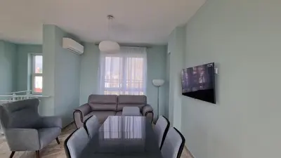a living room with a couch and a table and chairs at Panoramic Penthouse Apartment in Varna City