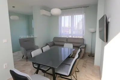 a living room with a table and chairs and a couch at Panoramic Penthouse Apartment in Varna City